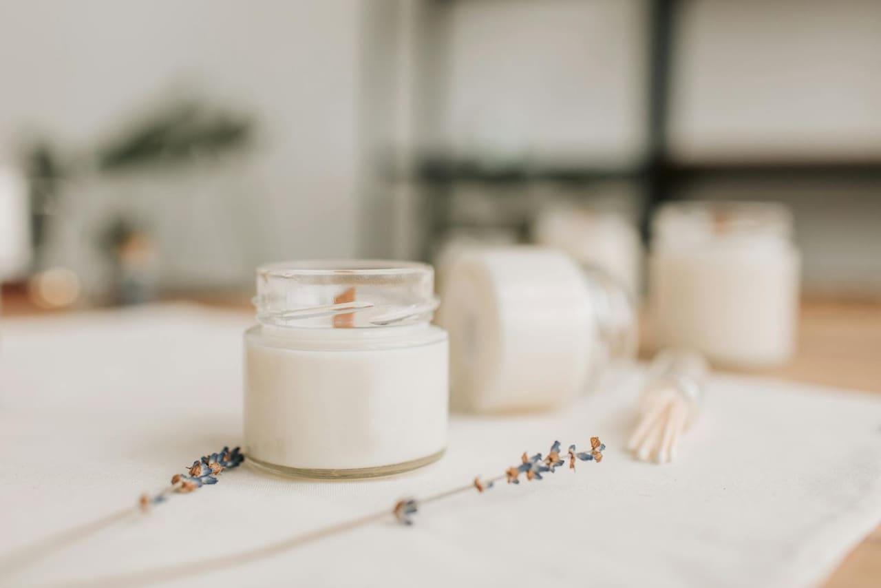 A lit candle beside dried flowers, a quiet memorial.