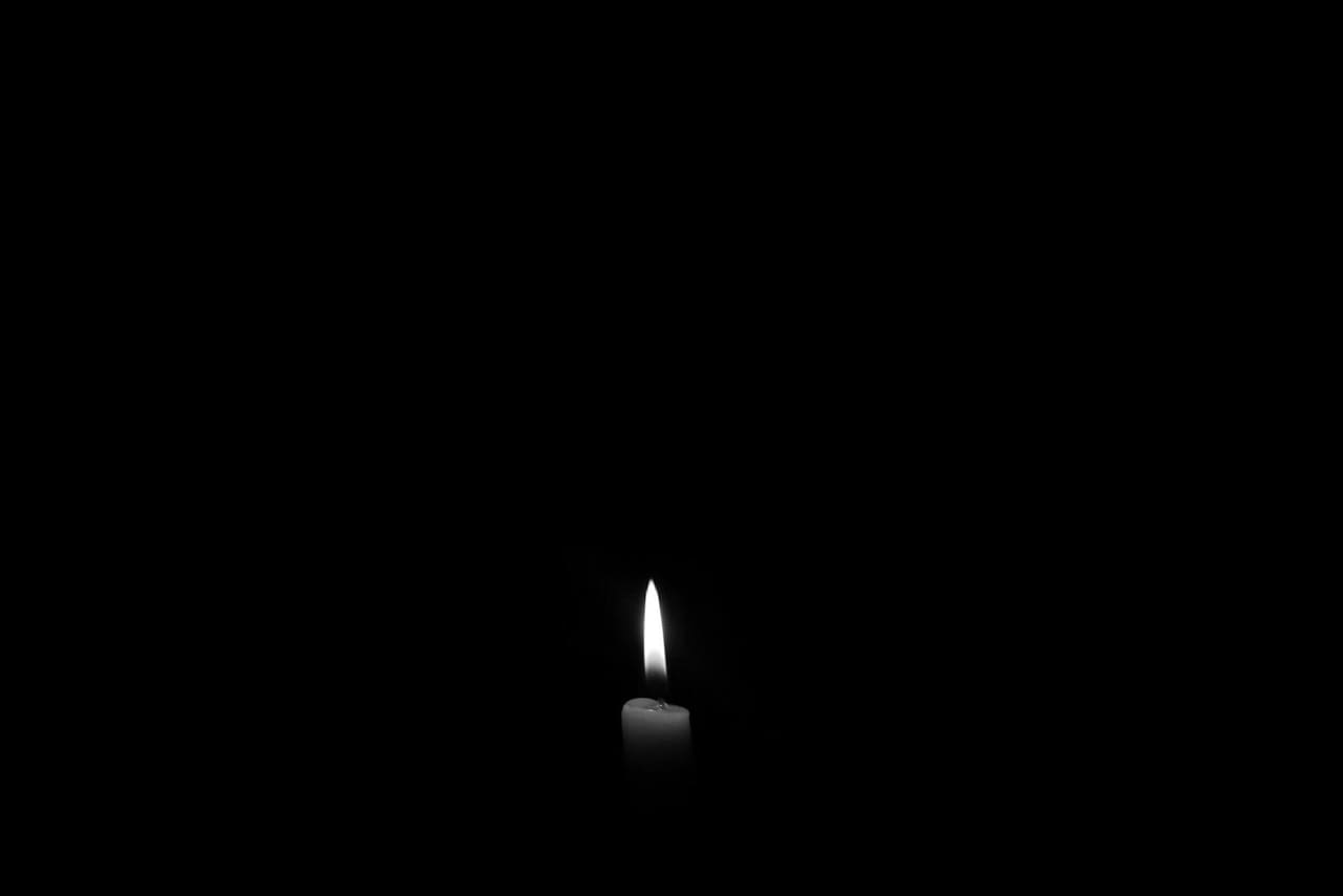 A single candle burning softly in the dark.