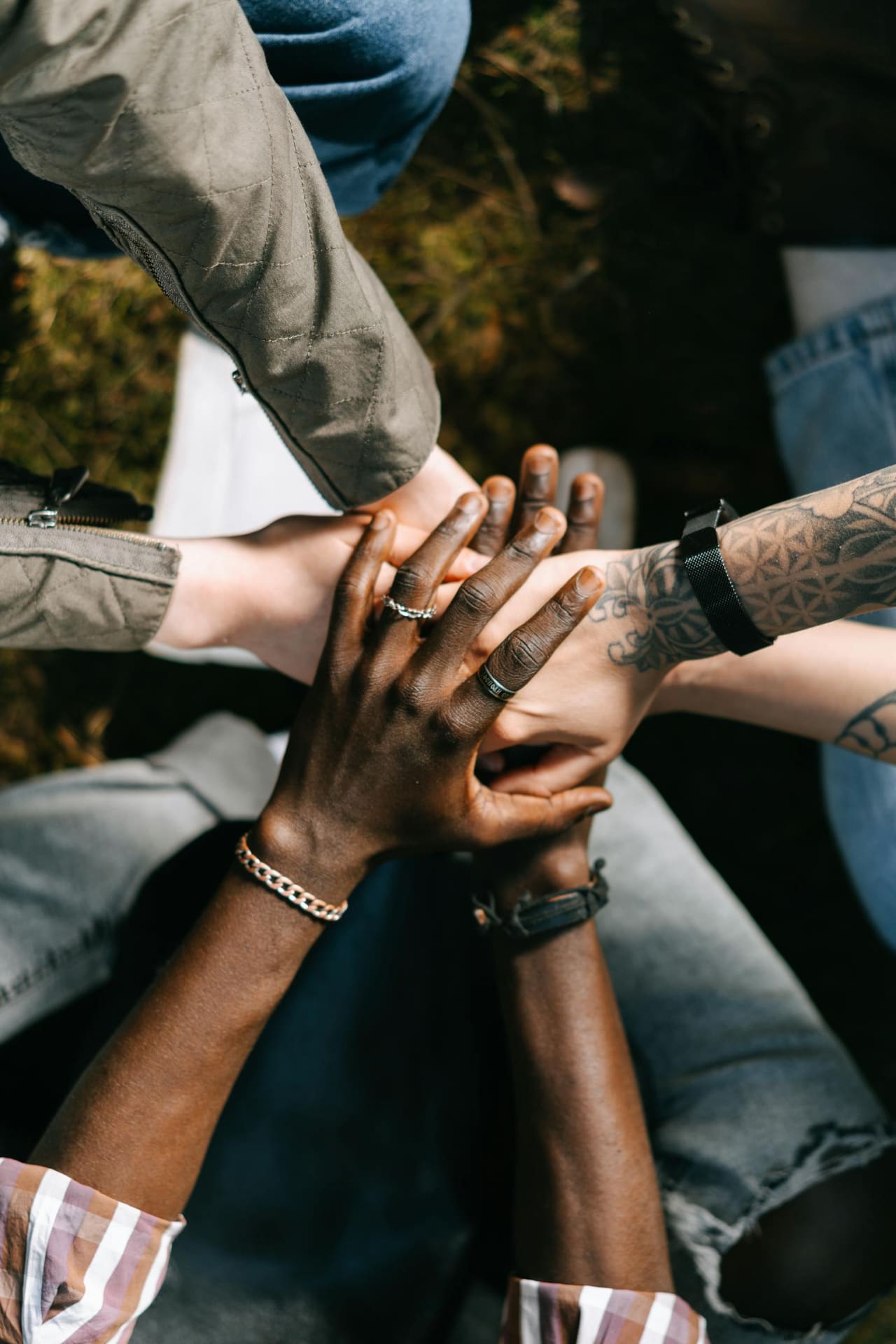 Several people's hands resting together in quiet support.