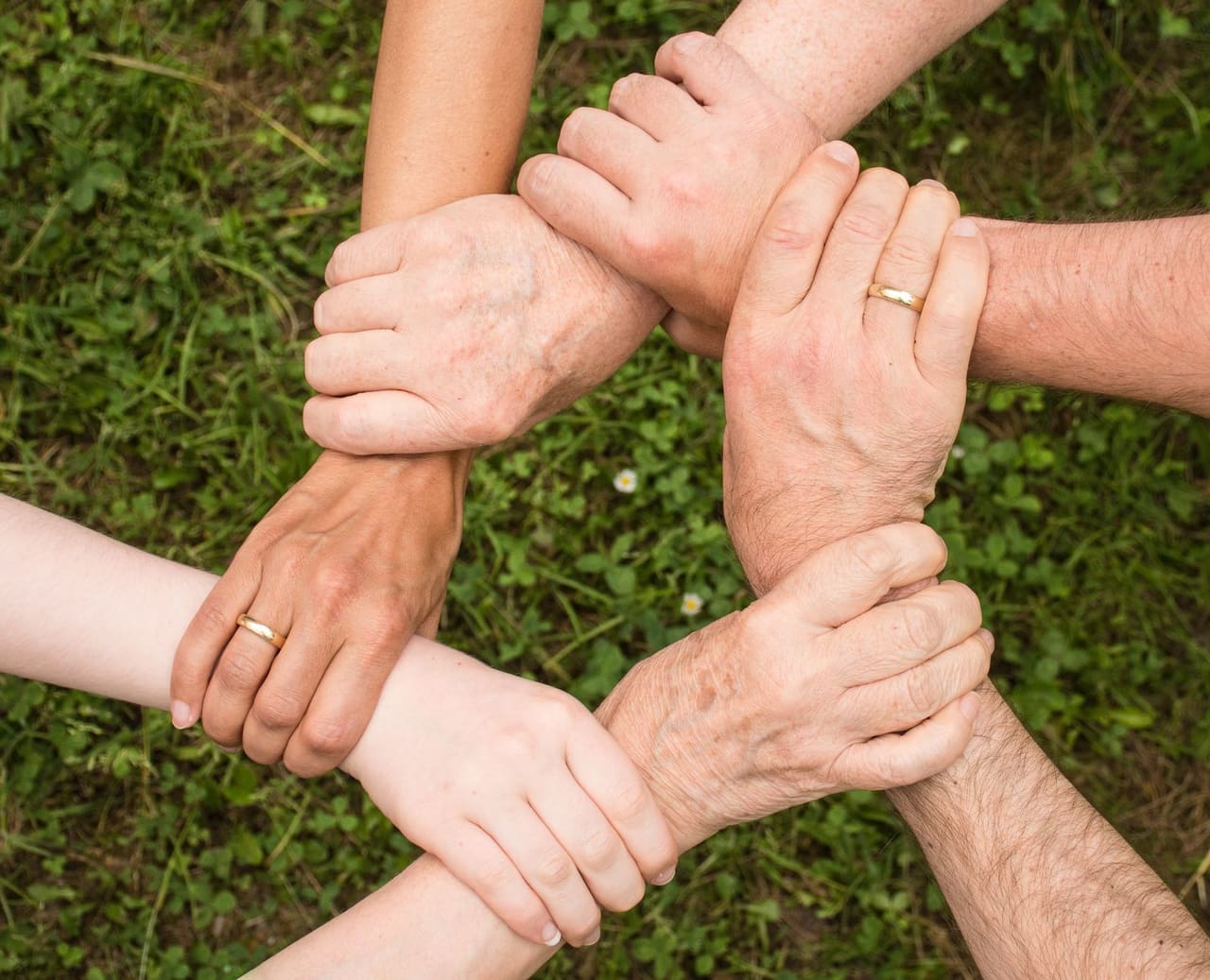 Several hands joined together in a circle of support.