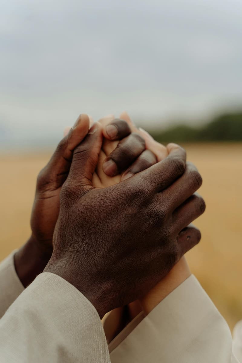 Two people holding hands in quiet comfort.